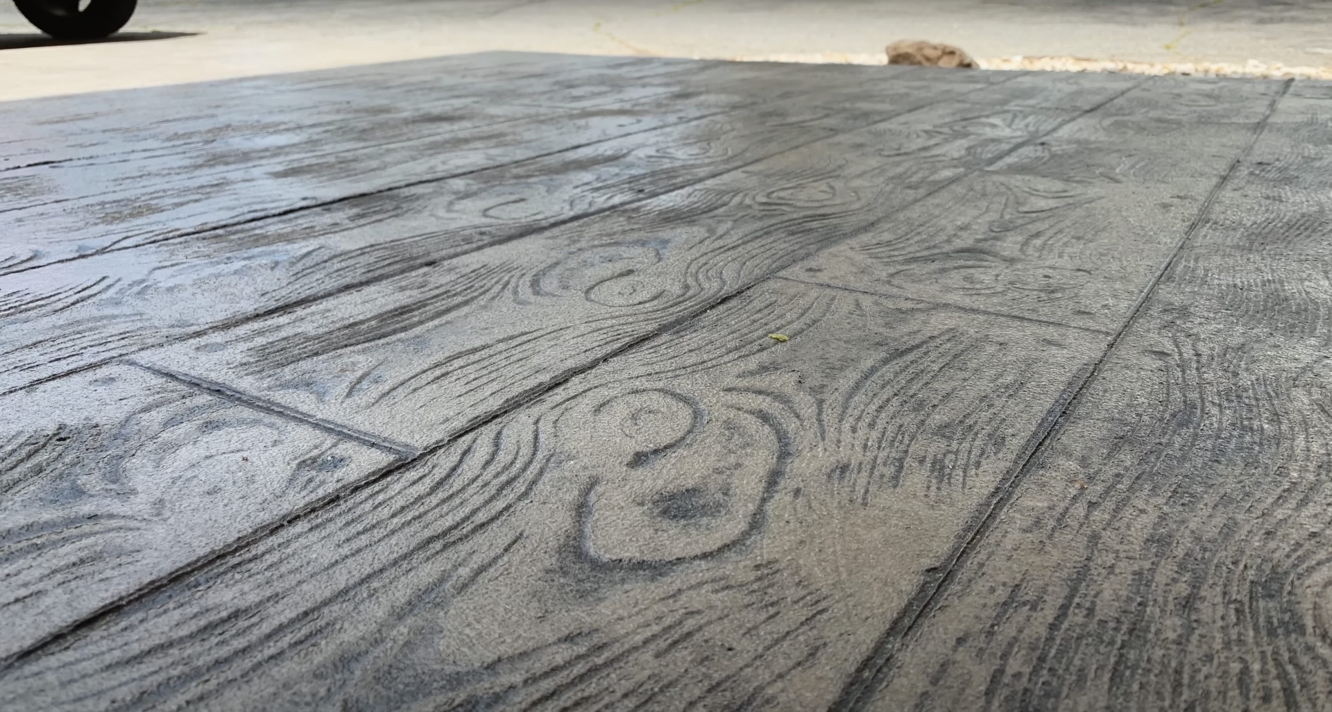 High-quality stamped concrete finish demonstrating expert craftsmanship and attention to detail Detailed view of stamped concrete showing intricate wood grain pattern and texture