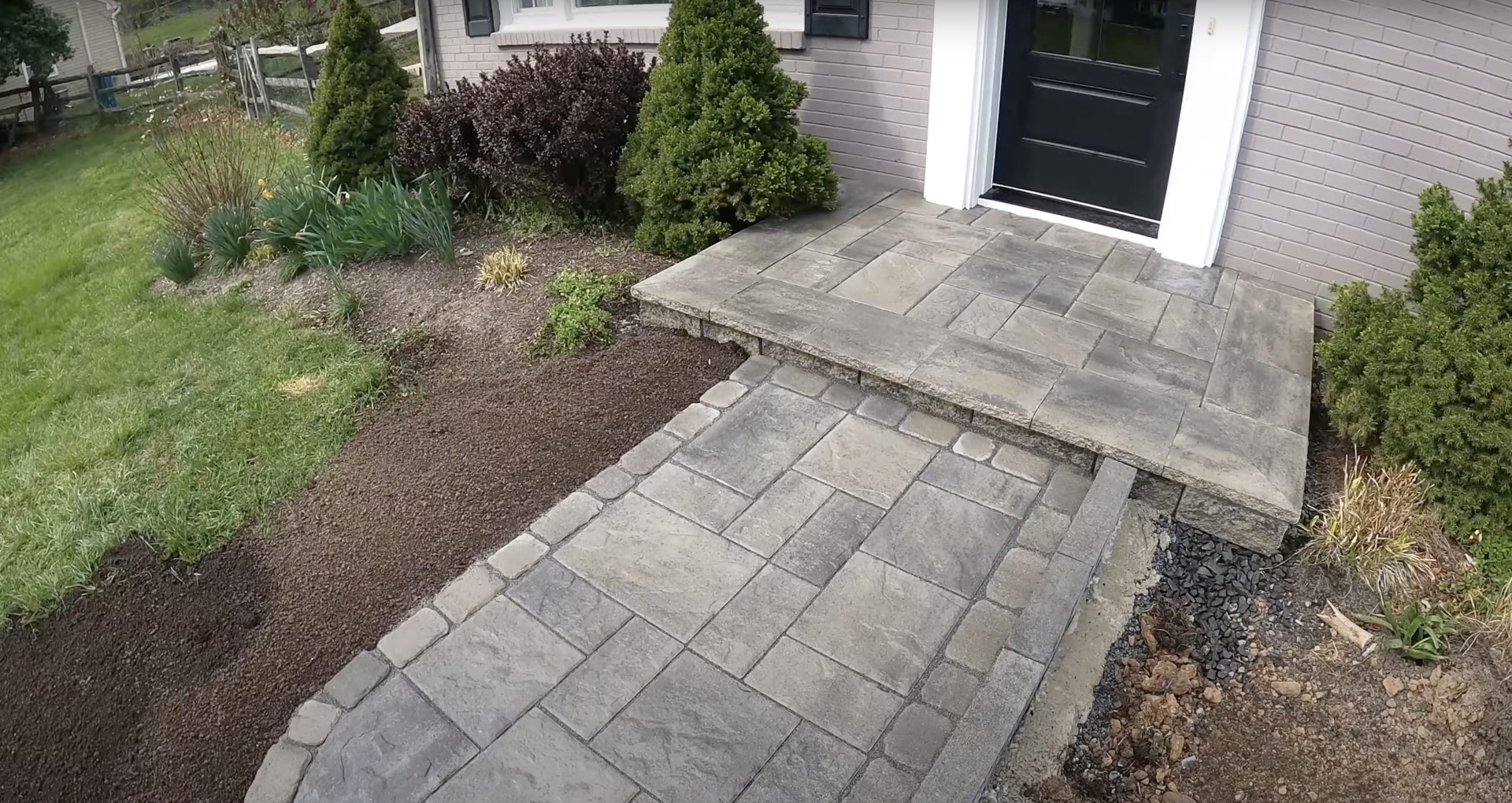 Custom concrete patio installation showcasing decorative stamped concrete techniques Modern concrete patio with decorative patterns leading to residential entrance