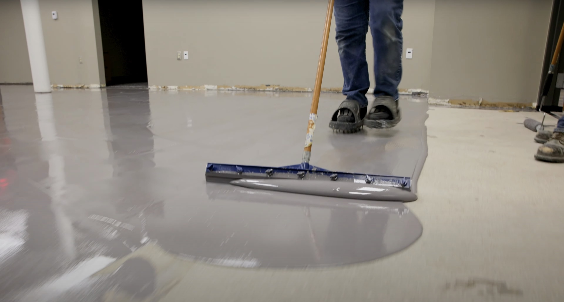 Professional concrete floor coating application with specialized equipment