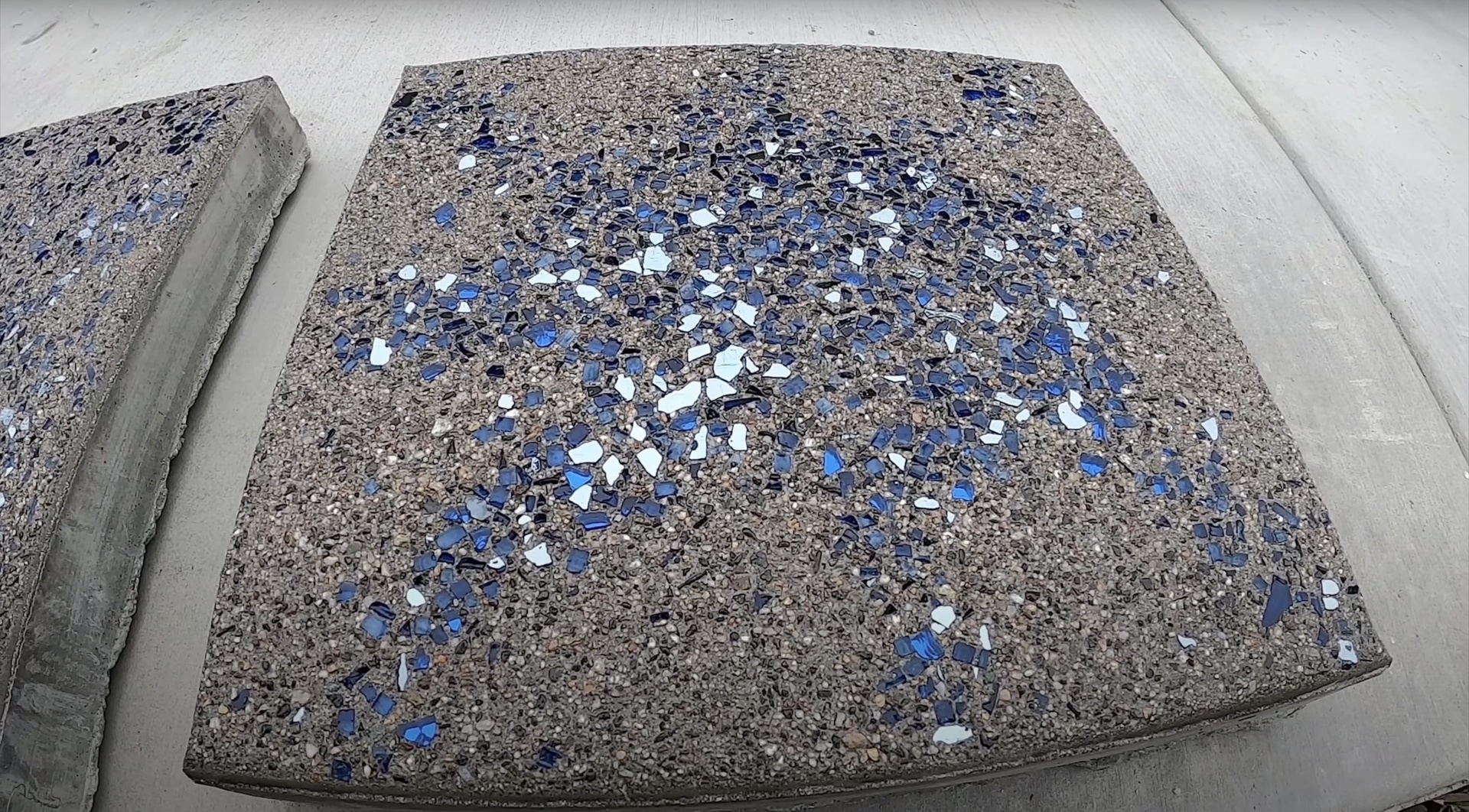 Decorative exposed aggregate concrete sample with blue and white stones